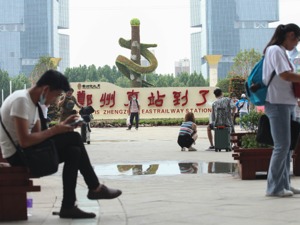 图集|滞留郑州东站旅客群像：车站栏杆上晾起衣服，小吃店人头攒动