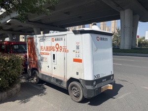 一线调研｜“9.9元跑30多公里”，青岛成无人车角力场：从低价抢客到基建卡位，新石器、九识、滴滴、货拉拉谁在抢跑？